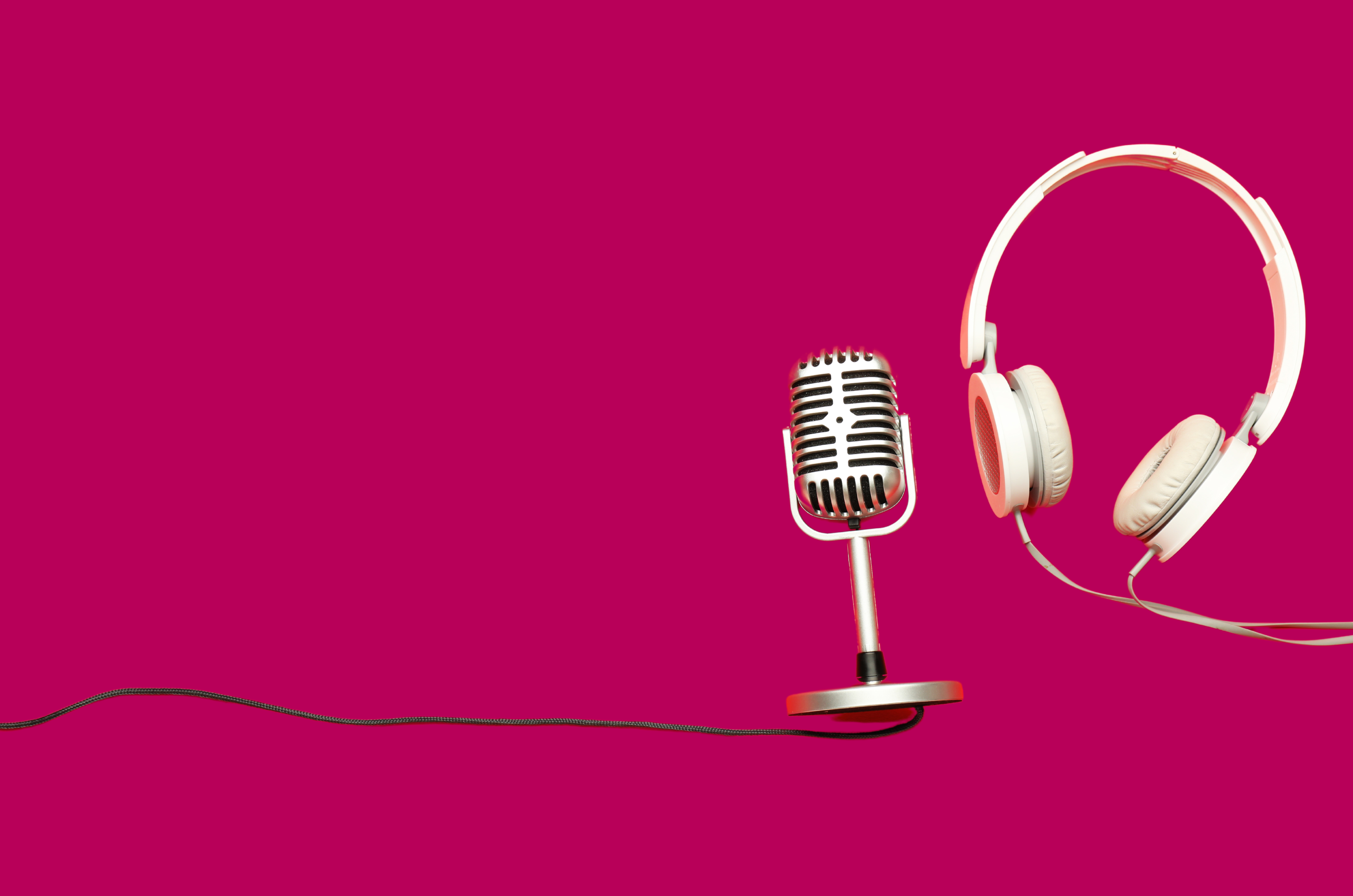 Headphones with silver microphone on hot pink background